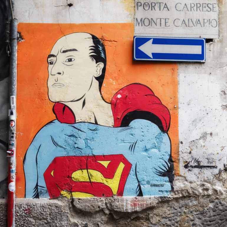 murales di totò supereroe con freccia cartello senso unico che indica totò.