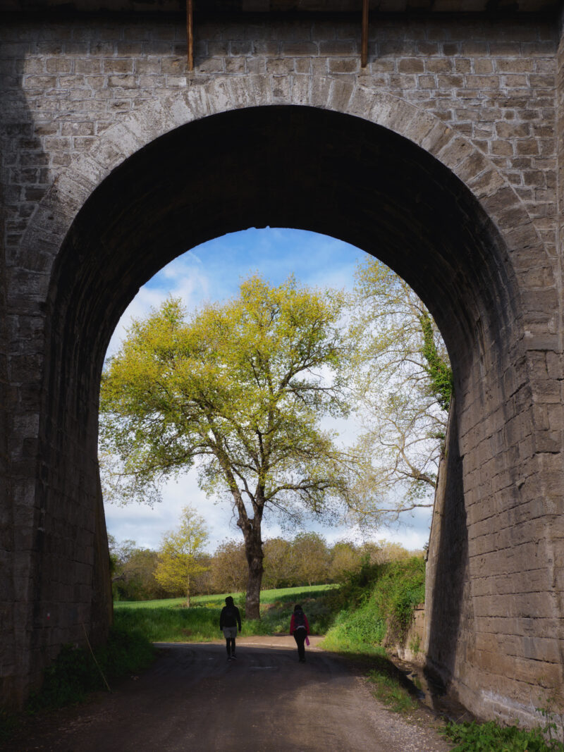 Pellegrini che attraversano un sottopasso ferroviario sulla via Francigena nel Lazio