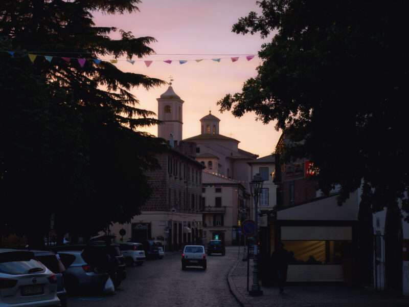 Strada acciottolata al tramonto a Vetralla con campanile illuminato dalla luce calda della sera