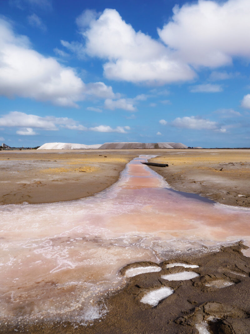 Rivolo arancione e rosa che conduce verso le montagne di sale