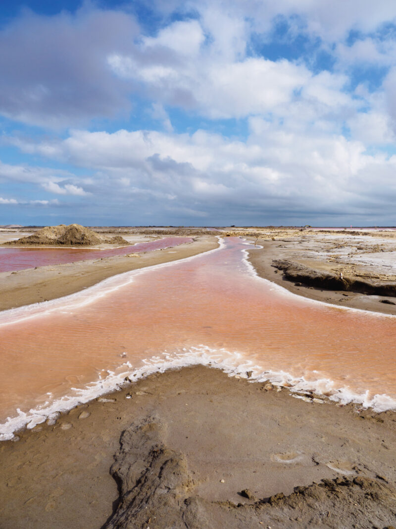 Rivolo d'acqua arancione tra argini di sale cristallizzato
