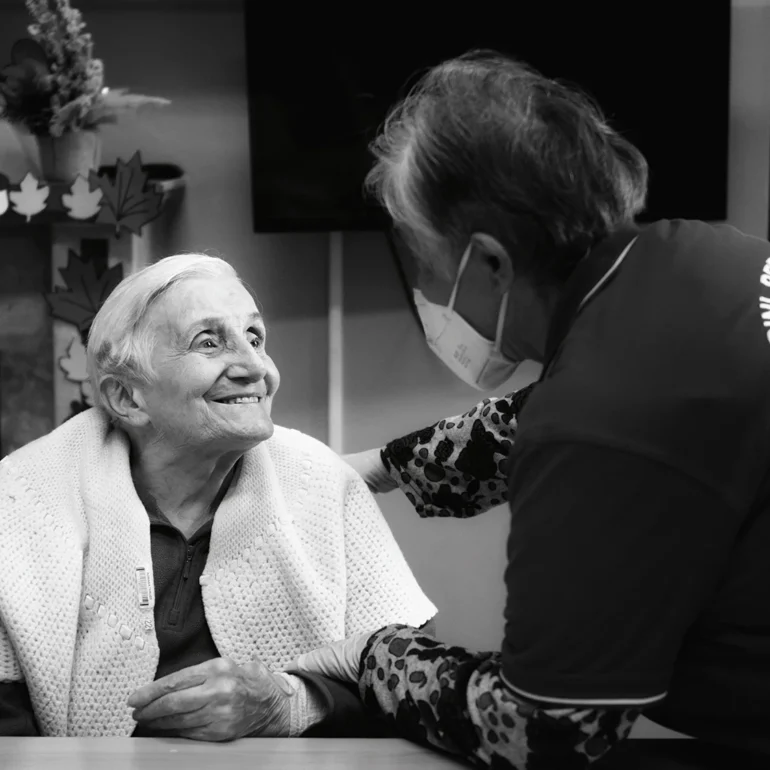 Anziana ad una casa di riposo che è flice di vedere signora che è venuta a trovarla