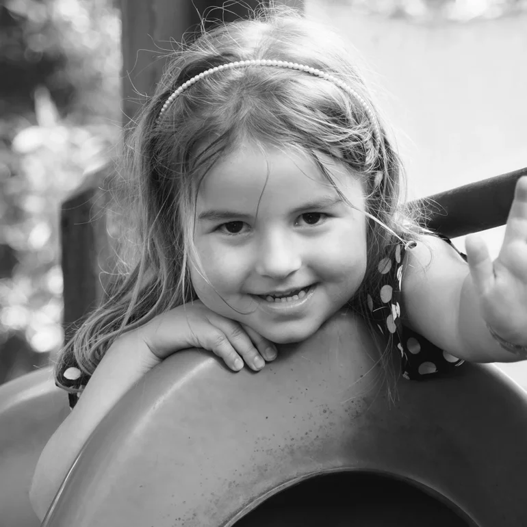 Bambina ad un aprco giochi con mano in avanti