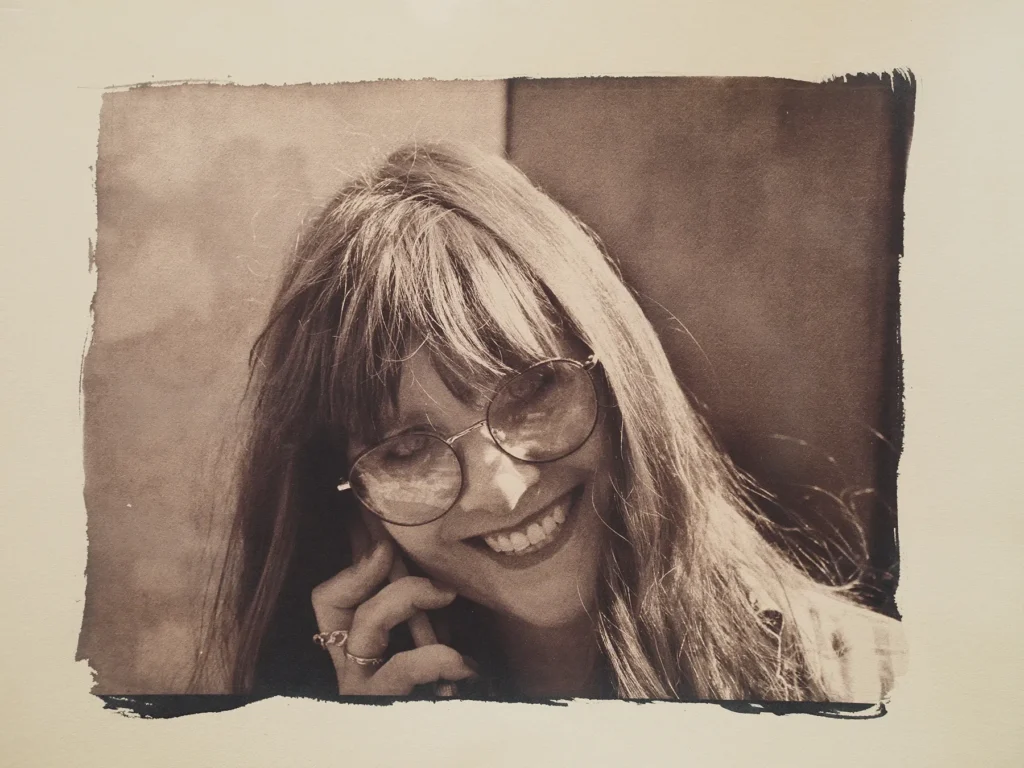 Ritratto di donna sorridente mentre parla al telefonino stampato con cianotipia con viraggio ai tannini