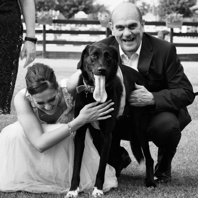 Ritratto tra padre, figlia che si sposa e cane inginocchiati mentre filgia muore dalle risate.