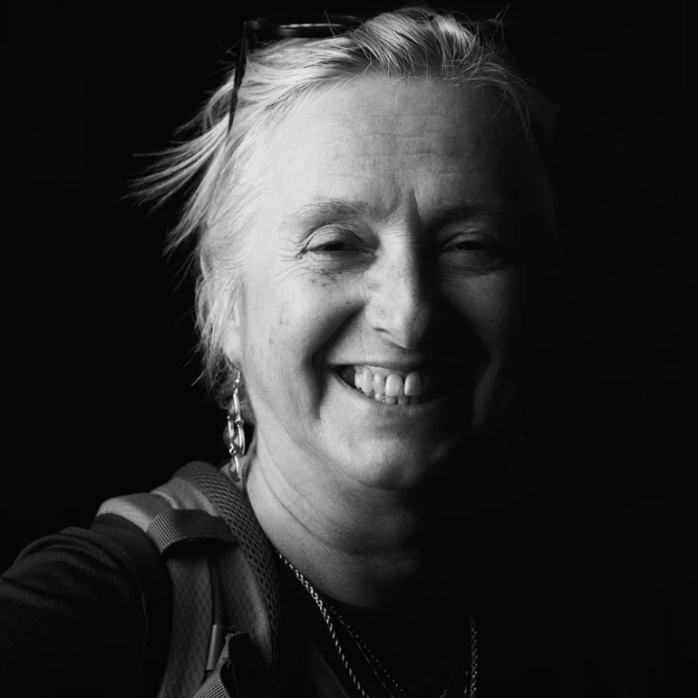 Ritratto primo piano con sfondo nero di una donna mezza età vestita sportiva