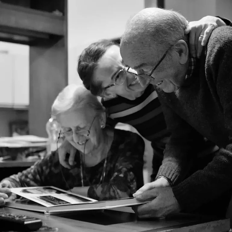 Ritratto di famiglia spontaneo in bianco e nero mentre guardano album di fotografie