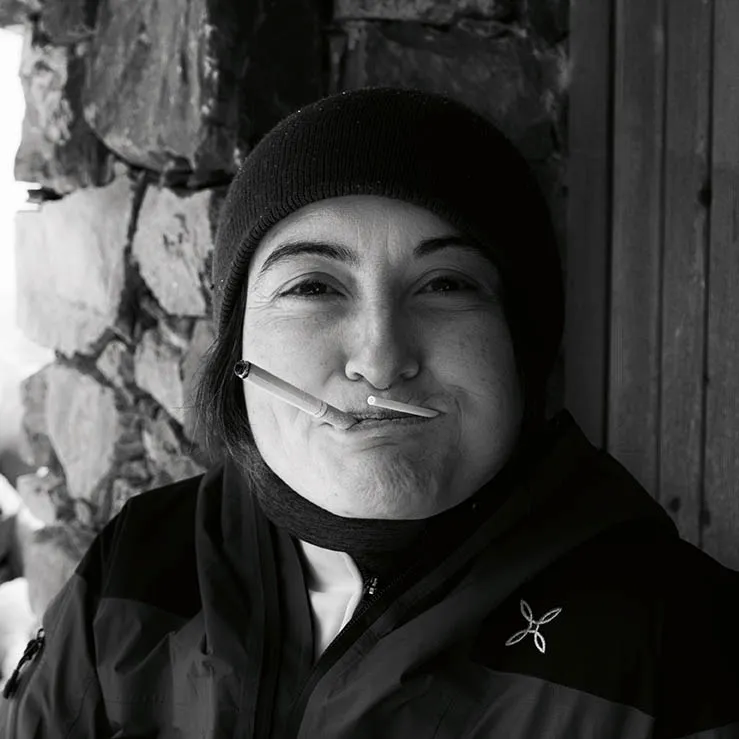 Ritratto di una donna in bianco e nero mentre fuma e succhia una Chupa Chups contemporaneamente