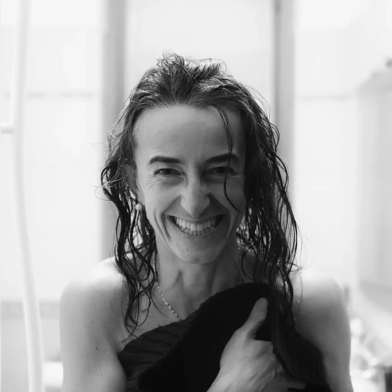 Donna viene ritratta appena fuori da doccia che sorride perchè presa alla sprovvista