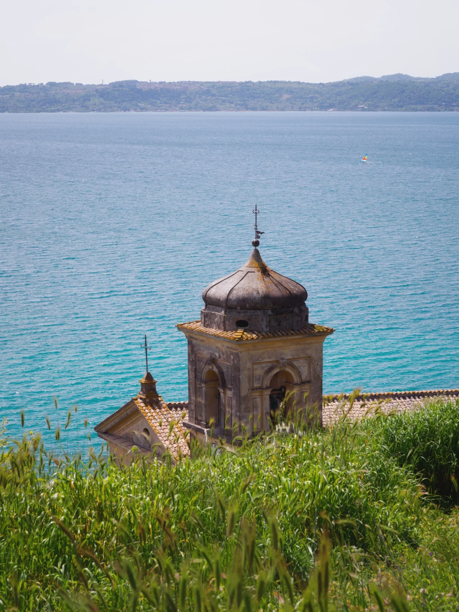 Campanile di una chiesa con cupola ottagonale affacciata sul lago di Bracciano